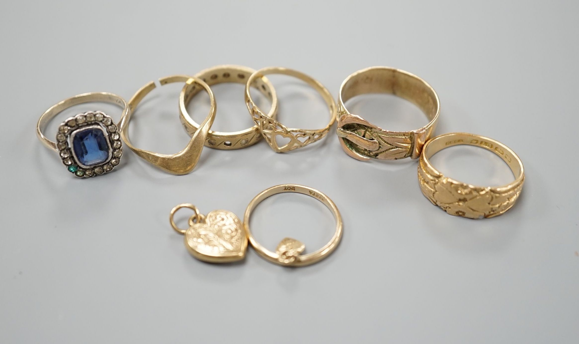 Four assorted 9ct gold rings, a 9ct gold heart pendant and a 9ct and paste set ring, gross 8.3 grams, an Edwardian 18ct gold ring, 4.4 grams and a yellow metal ring, 4 grams.